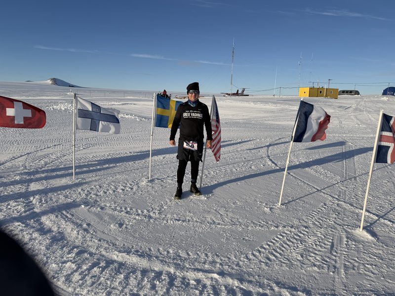 Standing among national flags on the ice at Union Glacier, Antarctica